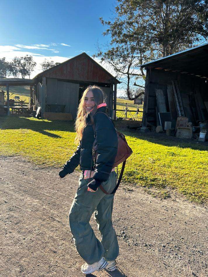 Stella walking across the Recipe of the Year set in a puffer jacket