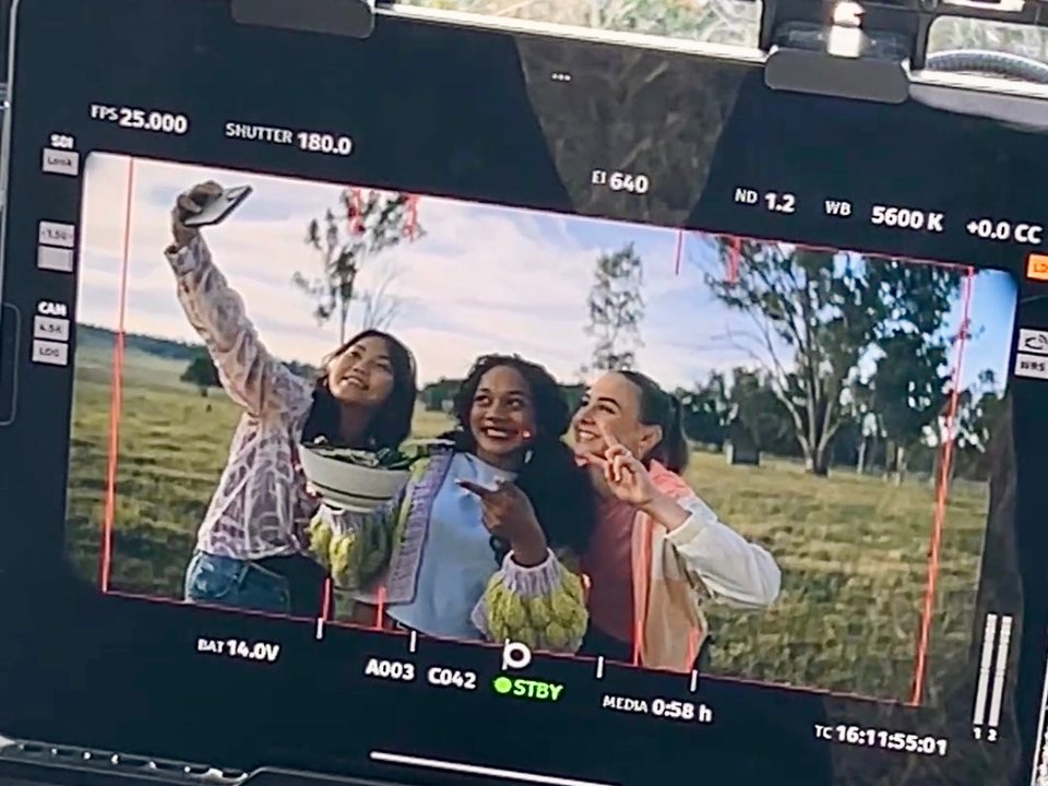Three girls watching themselves back on the monitor on the set of Recipe of the Year