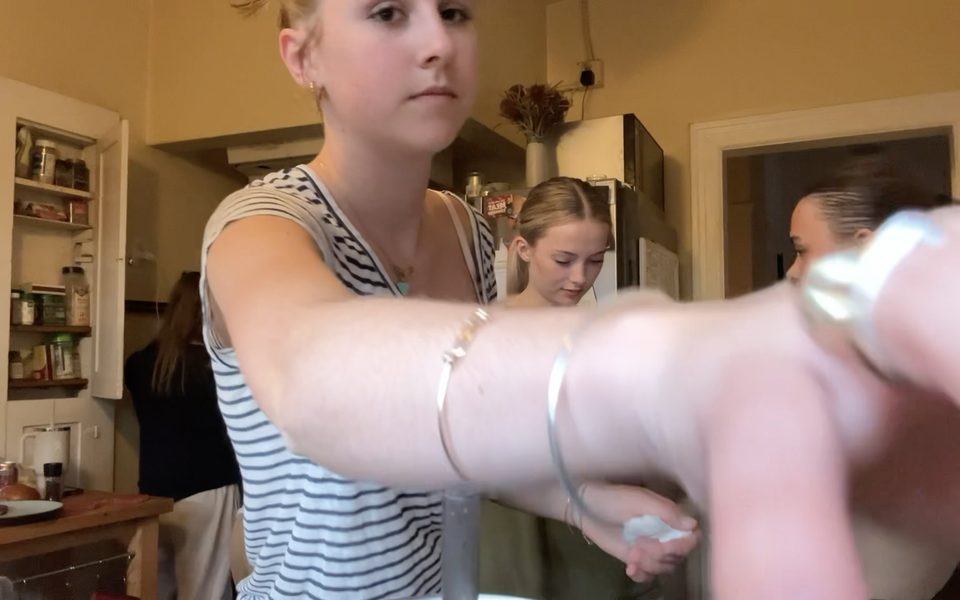 Stella pressing record on the camera, with bracelets on